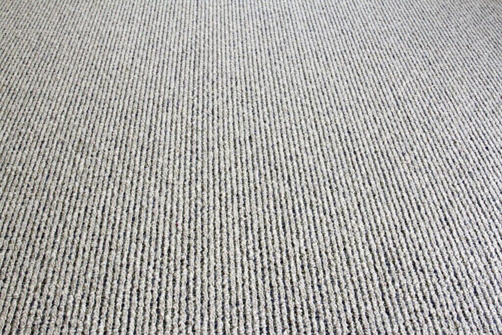 Soft beige textured carpet with subtle striped pattern, ideal for garden rooms and home interiors.
